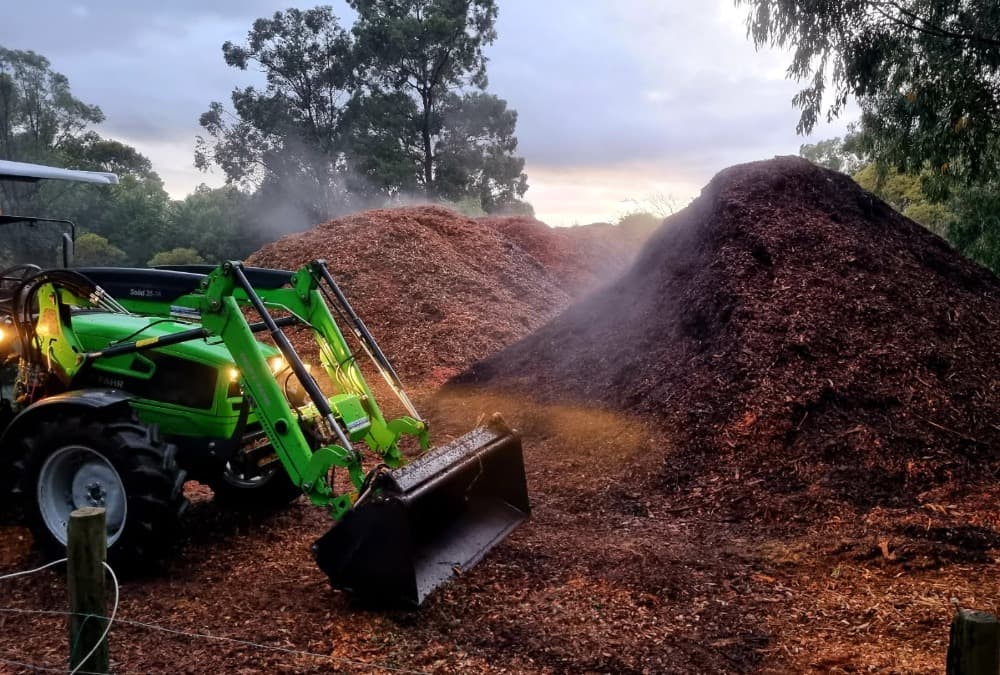 Mulch piles at dusk — land clearing job